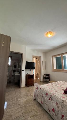 a bedroom with a bed and a bathroom with a television at Vita sul Garda in Bardolino