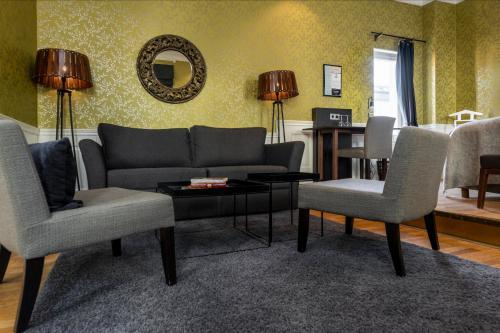 a living room with a couch and two chairs and a table at Home Hotel Plaza in Karlstad