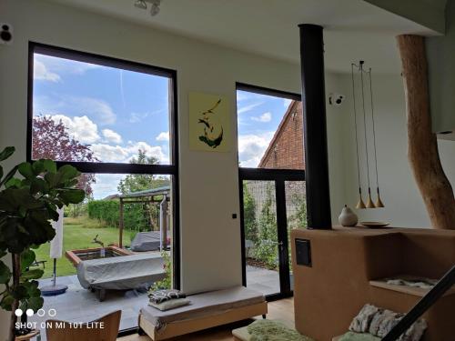 a living room with a door open to a patio at Luxury eco home with large garden and lots of light in Ons Belang