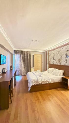 a bedroom with a large bed and a desk at Emsa Otel Maltepedeki Eviniz in Istanbul