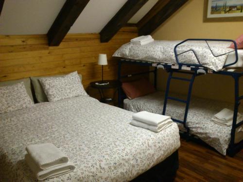 1 dormitorio con 2 literas y toallas en la cama en Pensión Panticosa, en Panticosa