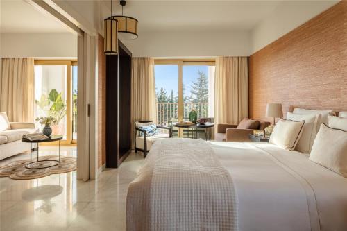 a bedroom with a large bed and a living room at Victoria Golf Resort and Spa Managed by Accor in Vilamoura