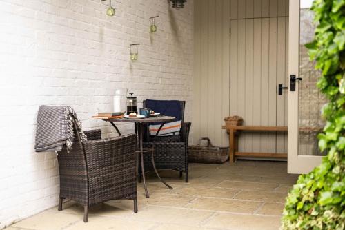 an outdoor patio with a table and chairs at The Cottages at Launceston Farm in Blandford Forum