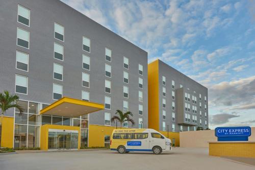 a white van parked in front of a building at City Express by Marriott Cancun Aeropuerto in Cancún