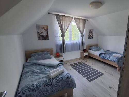 a bedroom with two beds and a window at Grofova Kuća in Lipovlje
