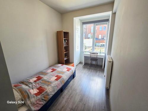 Un dormitorio pequeño con una cama y una ventana. en Splendid 2 bedroom apartment in Etterbeek, en Bruselas
