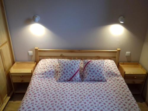 a bedroom with a bed with two lights on the wall at Las Góra Natura in Laskowa