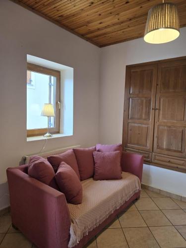 a purple couch in a living room with a window at KlaireyBelles in Dáfia
