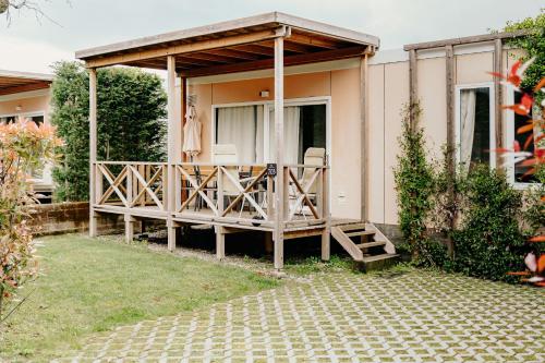 a house with a large deck with chairs on it at Camping Del Sole Village in Iseo