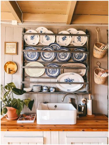 a kitchen with blue and white plates and a sink at Elins gjestehus in Egersund