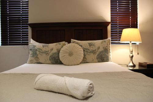 a bed with a pillow and a towel on it at Abiento Guesthouse in Bloemfontein
