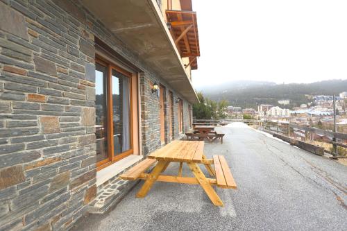 - une table de pique-nique en bois sur le côté du bâtiment dans l'établissement Chez Maguy appartements, aux Angles