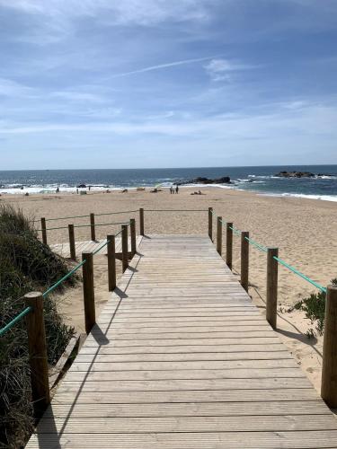 a wooden boardwalk leading to a beach with the ocean at nearsea in Lavra