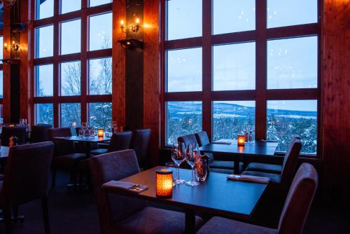 a restaurant with tables and chairs and large windows at Stöten Mitt Lägenheter in Sälen