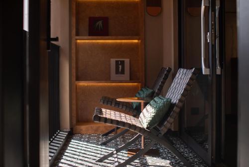 two chairs sitting in a hallway with a table at SIXI CANGSHAN MOUNTAINS GOLDEN SUNRISE MIRROR OF THE SKY SOUND SLEEP HOTEL DALI ANCIENT CITy in Dali