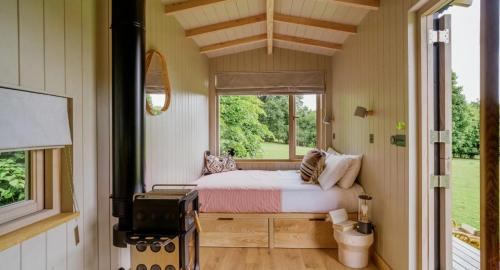 une petite chambre avec un lit et une fenêtre dans l'établissement River Cottage HQ, à Musbury