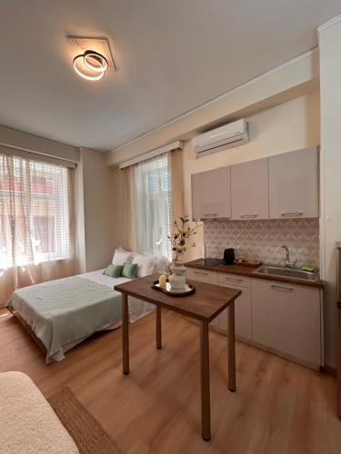 a bedroom with a bed and a table and a kitchen at Aurora Apartments in Mytilini