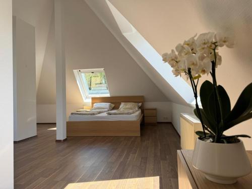 a bedroom with a bed and a vase with white flowers at Villa Am Park in Bad Homburg vor der Höhe