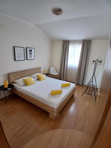 a bedroom with a bed with yellow pillows on it at Apartmani Fani 2 min walking from sea in Orebić