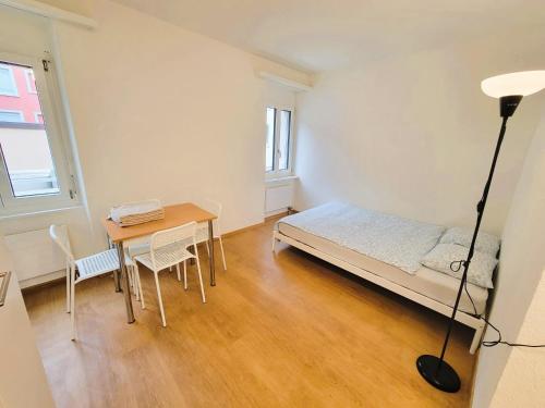 a bedroom with a bed and a table and a desk at Zurich City Center Apartments next to Zurich HB Main Train Station LA - Self Checkin in Zürich