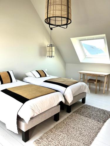 une chambre avec deux lits et une table et une fenêtre dans l'établissement Maison familiale cosy proche mer Agon Coutainville, à Agon-Coutainville