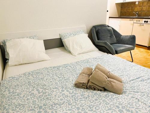 a bedroom with a large bed with a chair at Zurich City Center Apartments next to Zurich HB Main Train Station LA - Self Checkin in Zürich