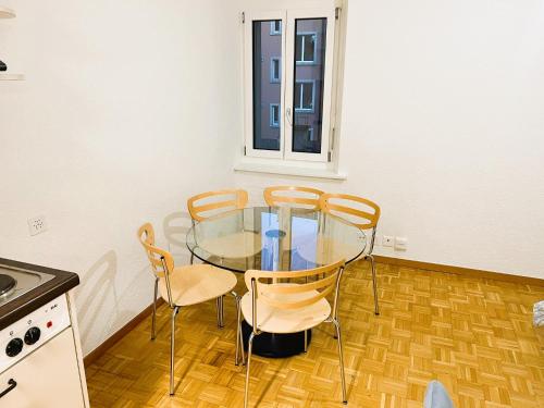 a kitchen with a glass table and four chairs at Zurich City Center Apartments next to Zurich HB Main Train Station LA - Self Checkin in Zürich