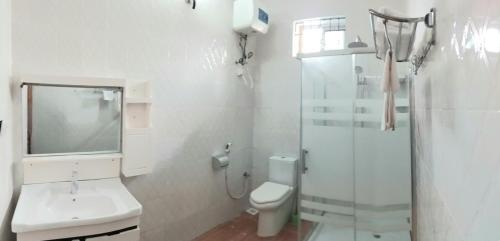 a white bathroom with a toilet and a shower at Sinthia Hotel Apartments in Chaki Chaki