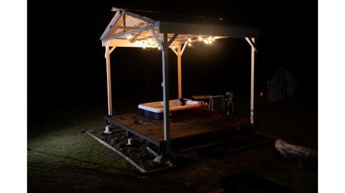 a bed in a pavilion at night at Odyssean Tiny House B by Tiny Away in Cessnock