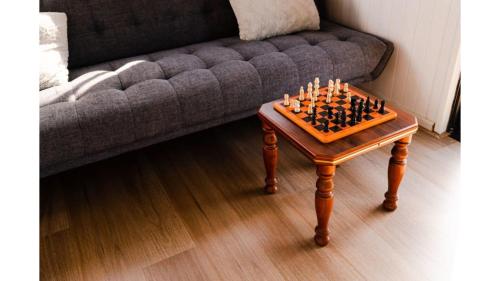 a chess board on a table in front of a couch at Odyssean Tiny House B by Tiny Away in Cessnock