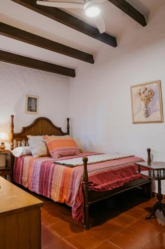 a bedroom with a bed with a wooden head board at Villa en Cala Morell con piscina privada en el bosque in Cala Morell