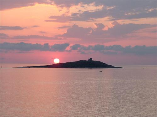 a sunset over an island with a castle on it at Saracen Sands Hotel & Congress Centre - Palermo in Isola delle Femmine