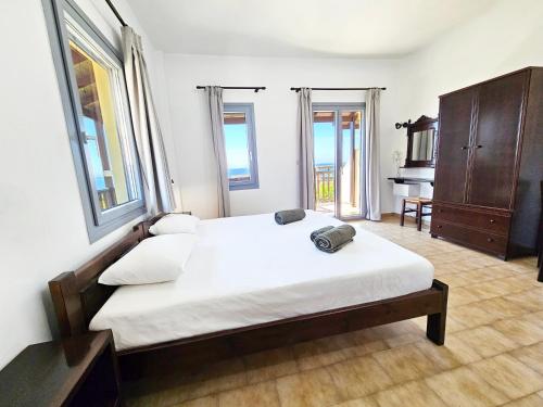 Un dormitorio con una cama, una cómoda y ventanas. en Studio Popi, en Marathokampos