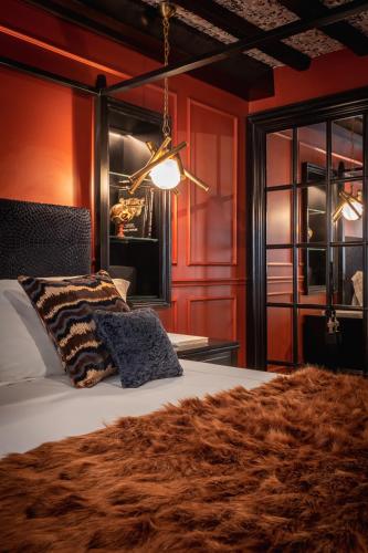 a bedroom with red walls and a bed with a brown blanket at Pantheon Suite - Residenze di Charme in Rome