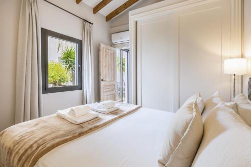 a bedroom with a white bed with two towels on it at Velamar in Aduanas