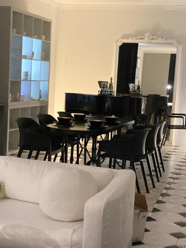 un salon avec une table et un piano dans l'établissement Villa Georges - La Rochelle centre -, à La Rochelle