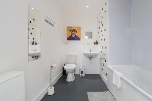 a white bathroom with a toilet and a sink at Stylish Modern Apartment by Aldgate East Station 5 in London