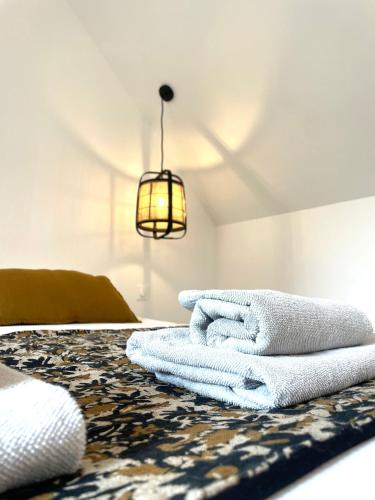 une chambre avec des serviettes sur un lit avec une lampe dans l'établissement Maison familiale cosy proche mer Agon Coutainville, à Agon-Coutainville