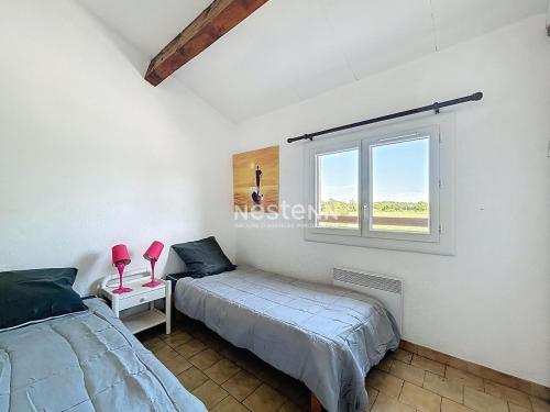 une chambre avec deux lits et une fenêtre dans l'établissement 3735- Maison à 400m de la mer, à Argelès-sur-Mer