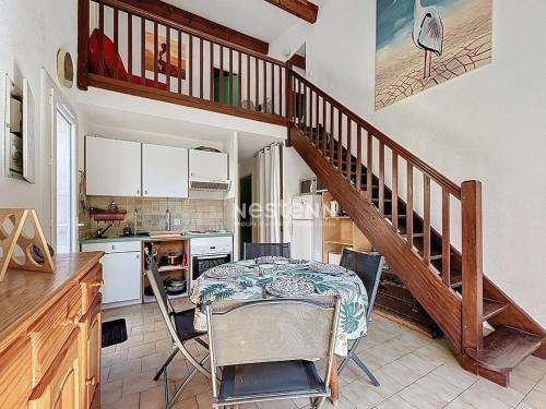 une cuisine avec une table et un escalier dans l'établissement 3735- Maison à 400m de la mer, à Argelès-sur-Mer