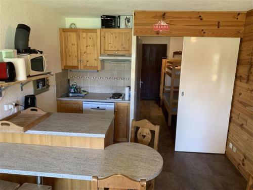 une cuisine avec une table et un réfrigérateur blanc dans l'établissement Plein Sud N2007 - ST4, à Les Deux Alpes