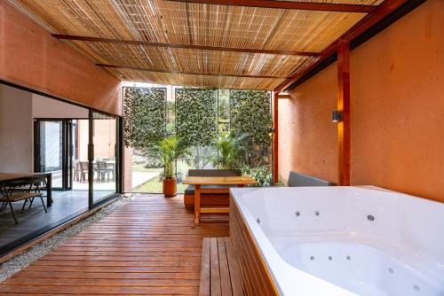 a large bathroom with a tub and a wooden floor at 5BR Poblado Villa close to Lleras Jacuzzi Cinema AC in Medellín