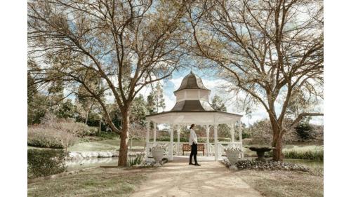 a man standing in a gazebo in a park at Odyssean Tiny House B by Tiny Away in Cessnock