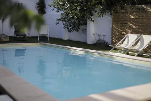 a large swimming pool with two lounge chairs in a yard at Water and Sun Studio in Lisbon