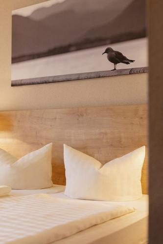 a bird sitting on top of a bed at Hotel Ahornhof in Lindberg