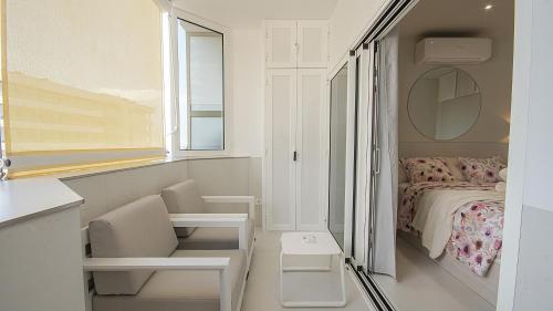 Mały, biały pokój z łóżkiem i oknem w obiekcie Atlantic Coast 'Princely' Apartment - Playa Del Inglés w mieście Playa del Ingles
