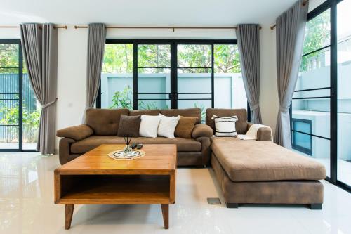 a living room with a couch and a coffee table at Ang Kaew Pool Villa 4BR 5 Min Drive to Nimmanhemin in Chiang Mai