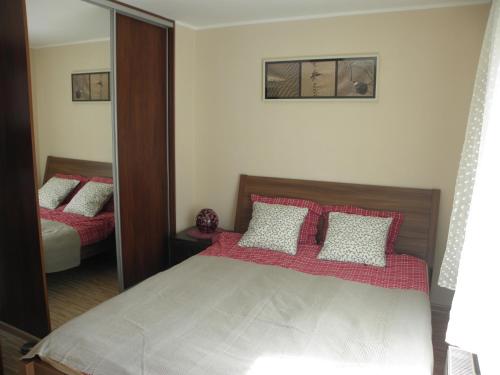 - une chambre avec un lit doté d'oreillers rouges et blancs dans l'établissement Apartament Sopot Oliwia, à Sopot