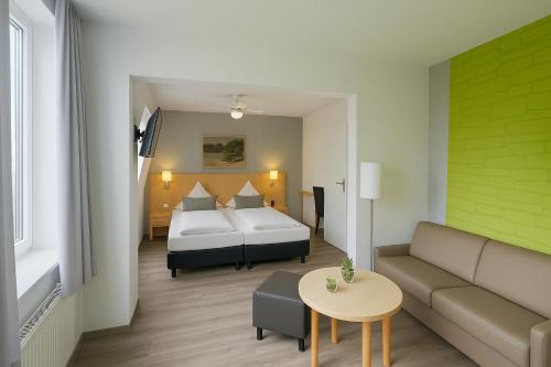 a hotel room with a bed and a couch and a table at Konsum Berghotel Oberhof in Oberhof