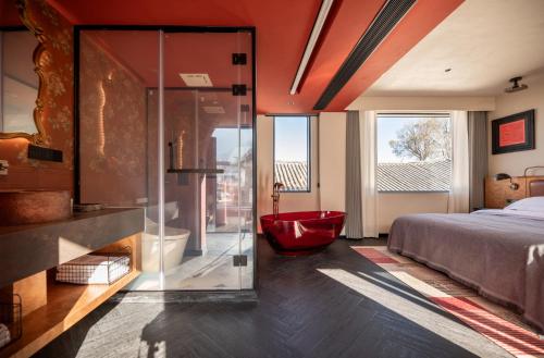 a bedroom with a large bed and a red tub at SIXI CANGSHAN MOUNTAINS GOLDEN SUNRISE MIRROR OF THE SKY SOUND SLEEP HOTEL DALI ANCIENT CITy in Dali